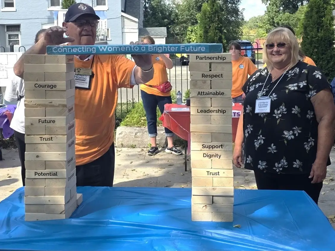 Brantford Expositor. Two People Building Bridge out of blocks